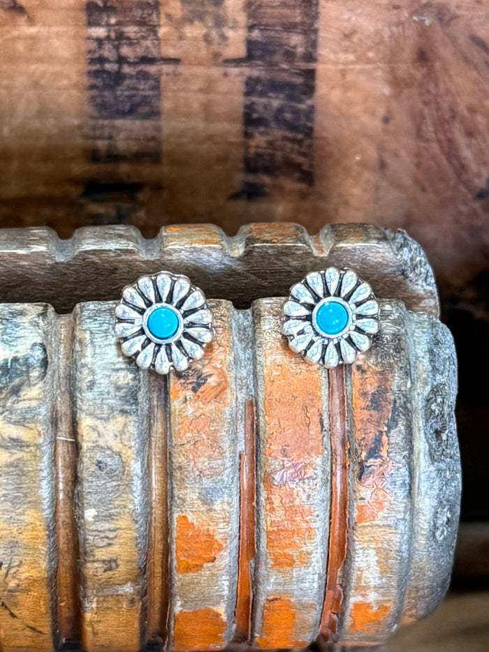 Silver-tone stud earrings with turquoise rosette centers and engraved concho sunburst details