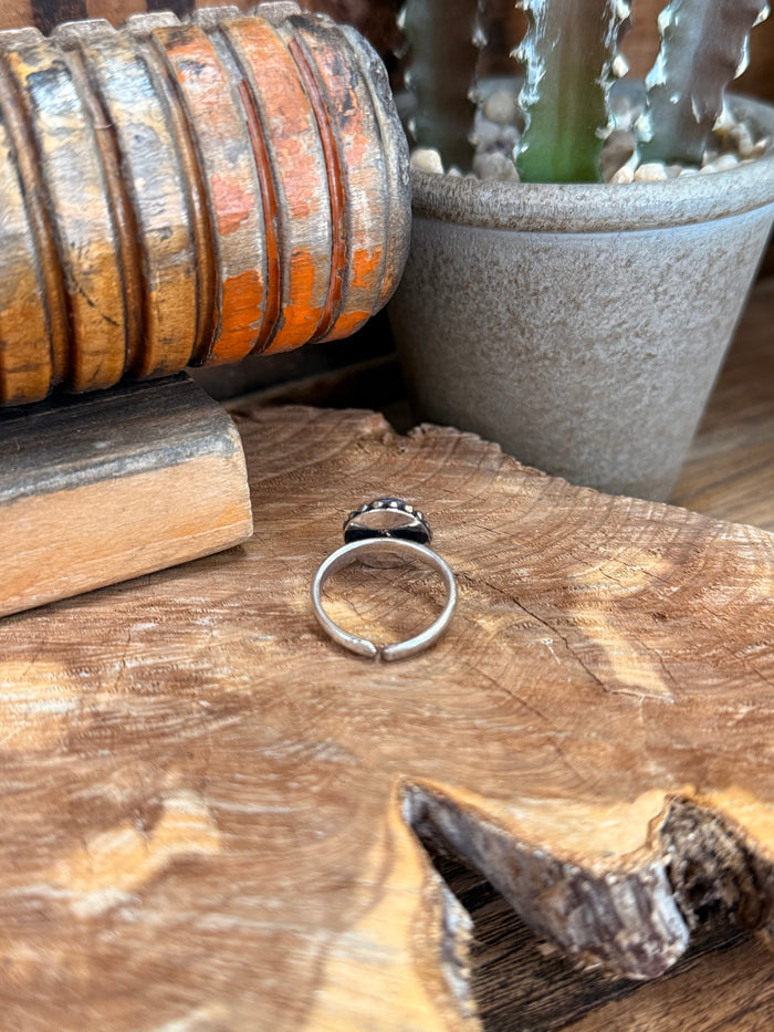Adjustable silver-tone ring with round blue gemstone, side view