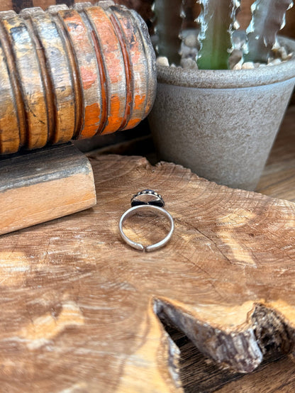 Adjustable silver-tone ring with round blue gemstone, side view