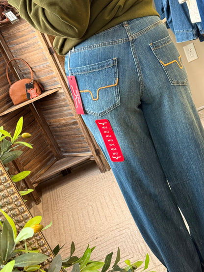 Maggie jeans side view, medium blue denim with flared back pocket and red tag