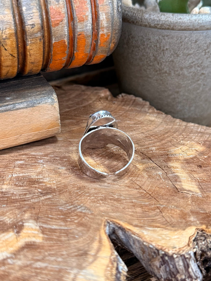 Adjustable silver-plated ring with oval blue lapis stone, side view of band
