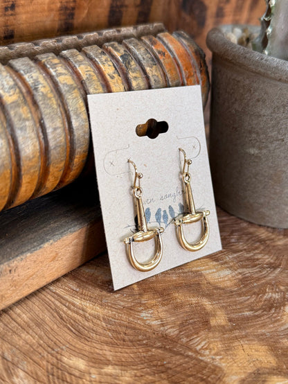 Gold-tone fishhook earrings with dangling snaffle bit charm and hoop drops