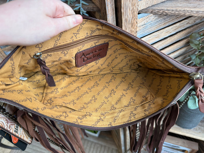 Fringe cowhide purse interior with tan patterned lining and zip-top closure