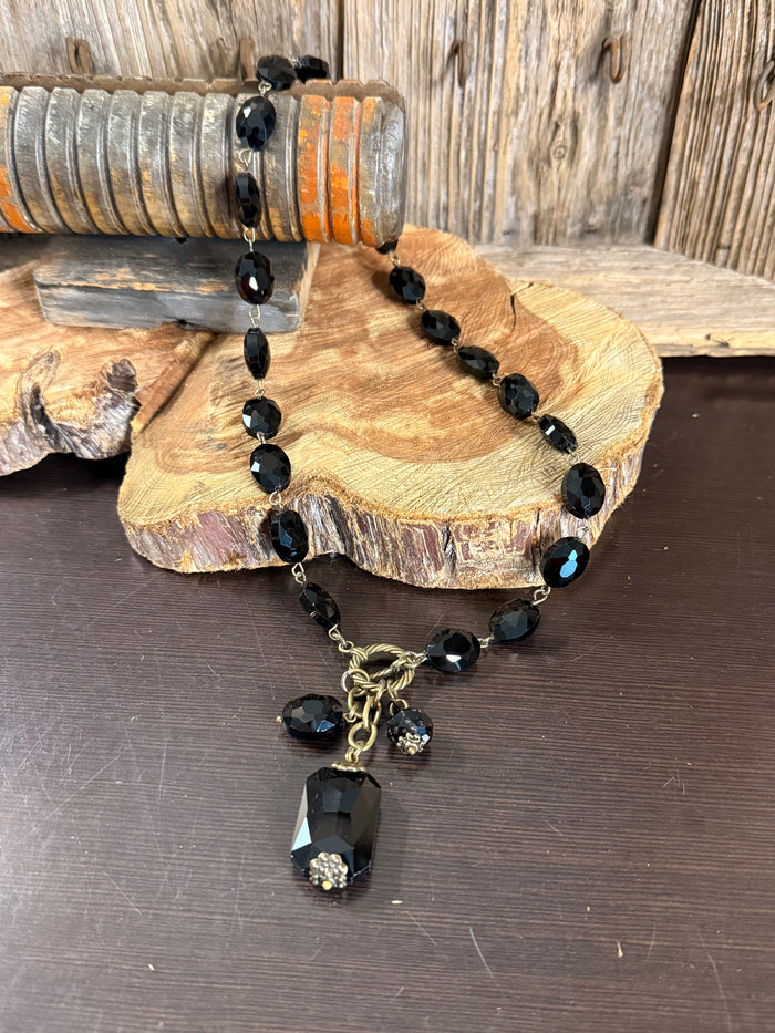 Black crystal bead necklace with faceted teardrop links and dangling charm pendant