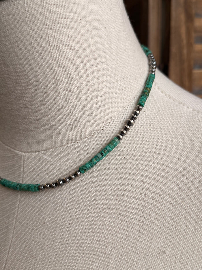 Close-up of green turquoise heishi beads with small sterling silver spacer beads