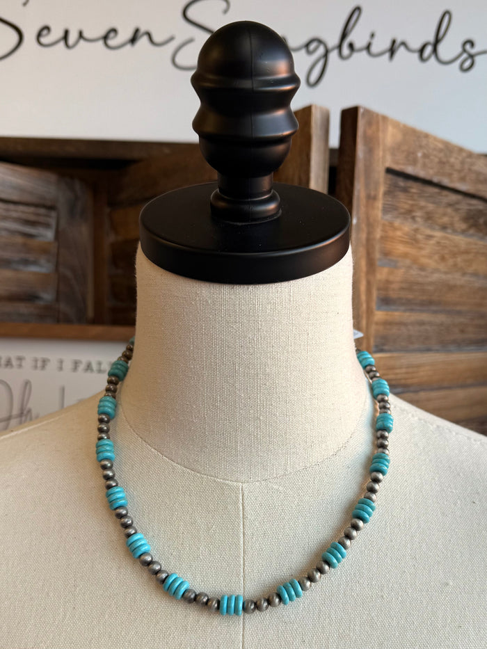Turquoise and silver beaded necklace on mannequin with layered strand and clasp