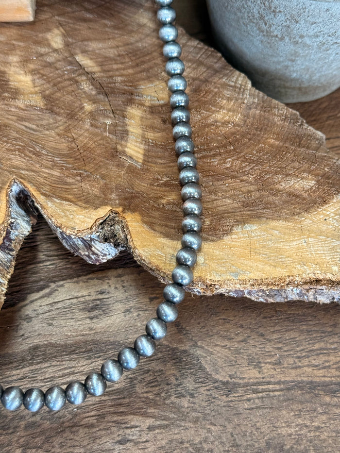 20-inch pearl necklace close-up of dark blue-gray bead strand with metal clasp