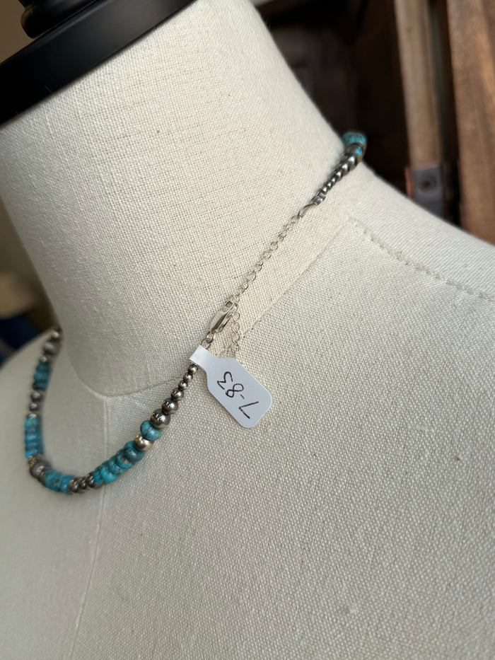 Turquoise and sterling silver bead necklace with small flower charm and hanging tag