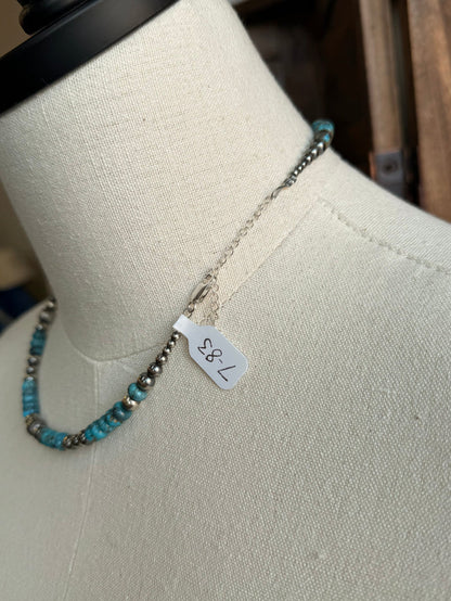 Turquoise and sterling silver bead necklace with small flower charm and hanging tag