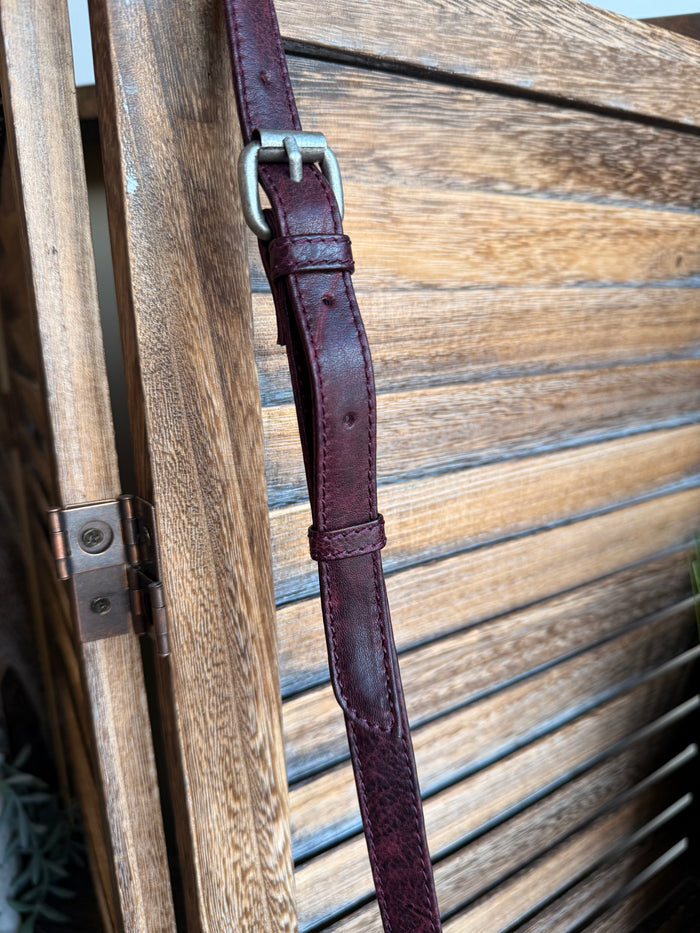 Plum leather crossbody strap with stitched edge and metal buckle clasp