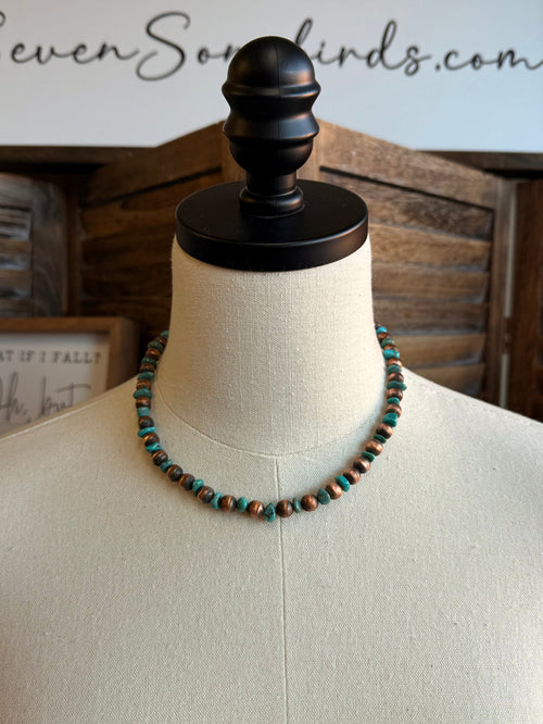 Beaded copper and turquoise necklace on a mannequin, round bead strand