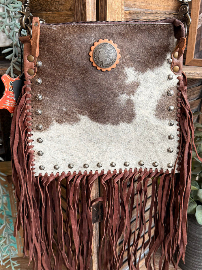 Cowhide crossbody coin purse with concho badge, silver studs, and dark leather fringe