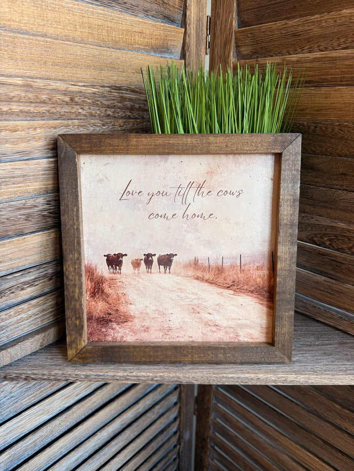 Framed wall art with cows and handwritten quote in rustic pasture scene