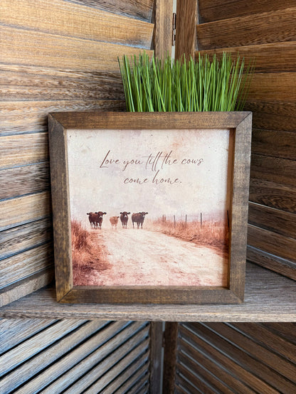 Framed wall art with cows and handwritten quote in rustic pasture scene