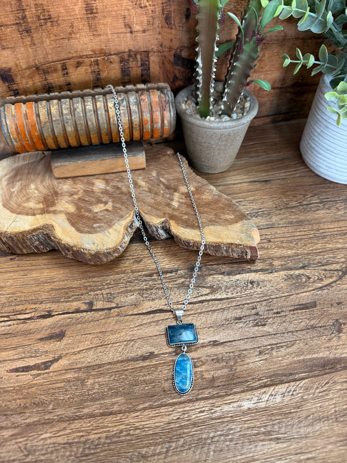 Silver lariat necklace with rectangular and oval blue stone pendants on a chain