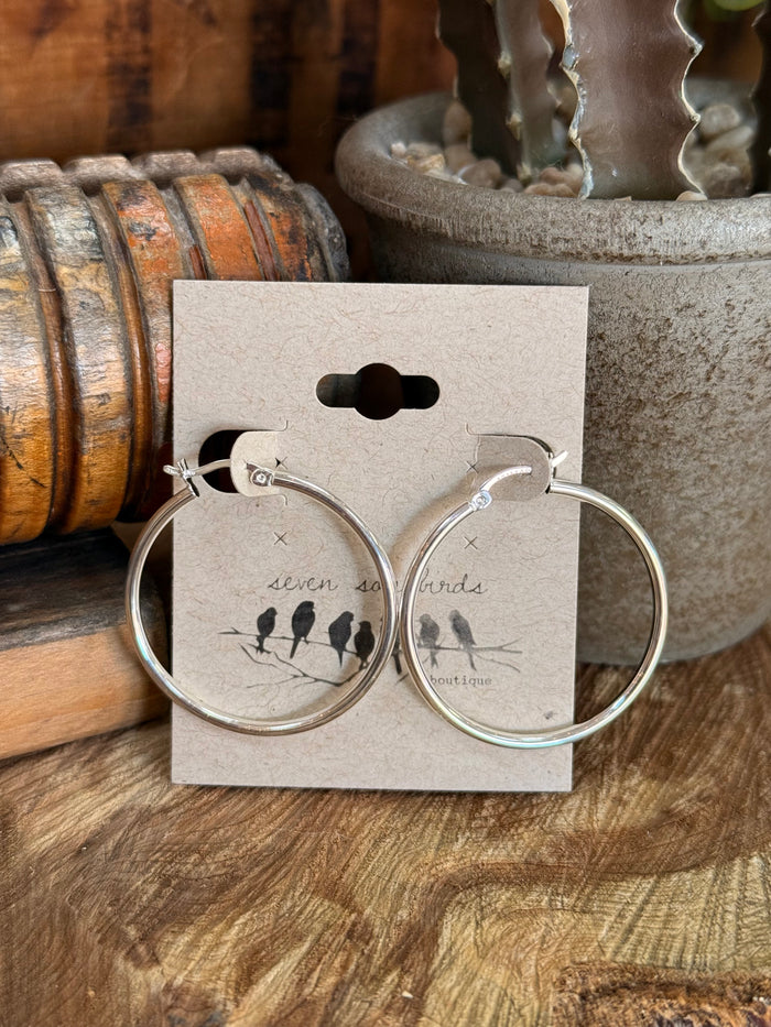 Sterling silver hoop earrings with black bead detail and small inner marks.
