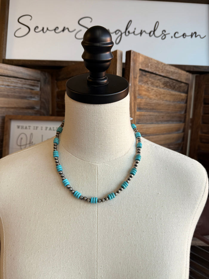 Turquoise and silver beaded necklace on mannequin, with short silver chain and clasp