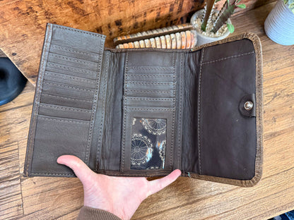 Open dark leather wallet with card slots and a small interior slip pocket