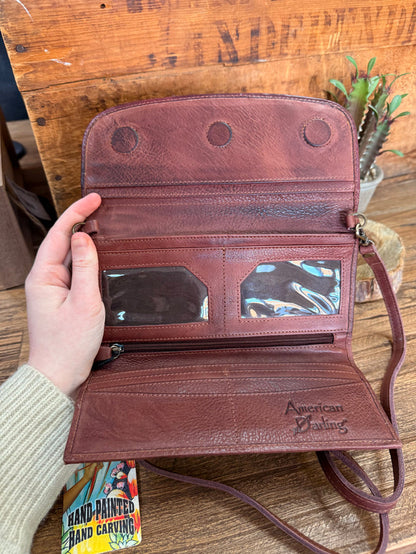 Burgundy leather crossbody wallet with snap flap, crossbody strap, and card slots