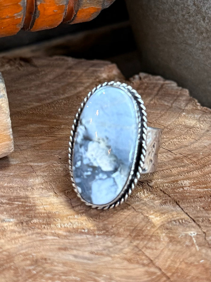 Blue oval cabochon stone ring with scalloped silver-tone bezel, adjustable band