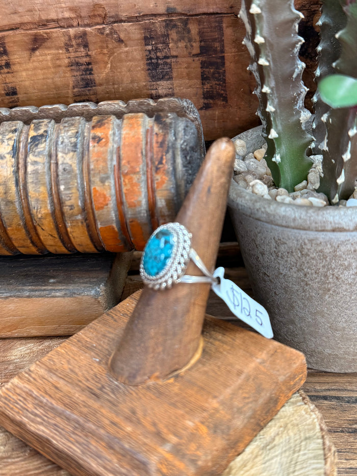 Turquoise oval sterling silver ring on wooden stand, twisted rope bezel with blue stone