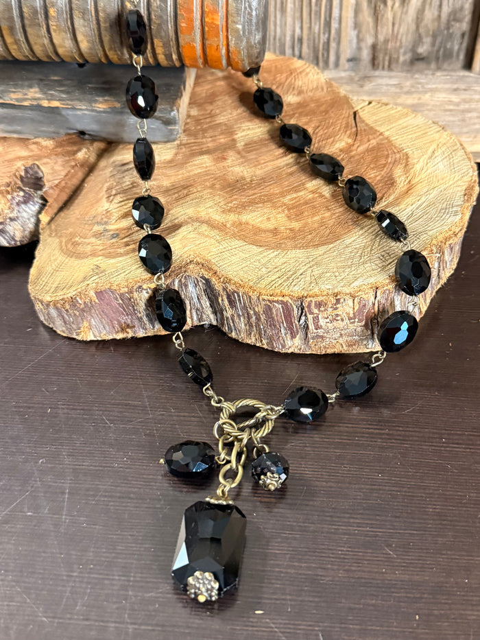 Black faceted crystal necklace with gold clasp and larger crystal pendant drop