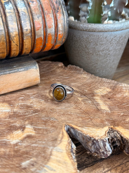 Silver adjustable ring with oval amber-tigereye stone set in ornate rope bezel
