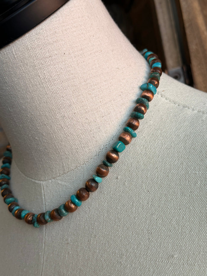 Close-up of copper and turquoise bead necklace with small round bead spacing