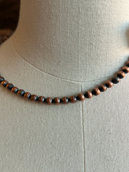 Close-up of a genuine copper bead necklace with small round copper-tone beads