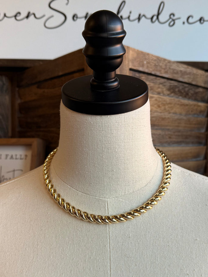 Chunky gold chain necklace on mannequin, thick interlinked curb chain, smooth sheen