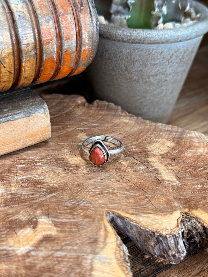 Adjustable silver-toned ring with oval red natural stone centerpiece