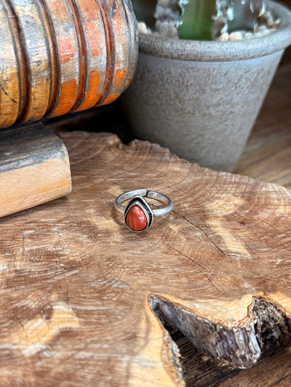 Adjustable silver-toned ring with oval red natural stone centerpiece