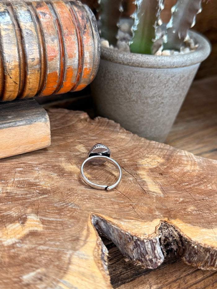 Silver adjustable ring showing underside open band and oval amber stone top