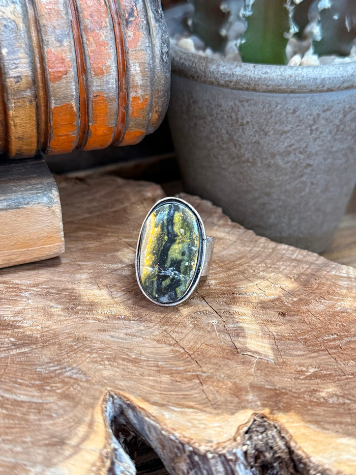 Adjustable ring with oval yellow-green stone cabochon and silver-plated bezel