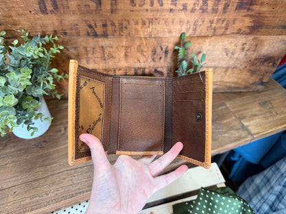 Trifold cowhide wallet interior with card slots, bill compartments, and snap button
