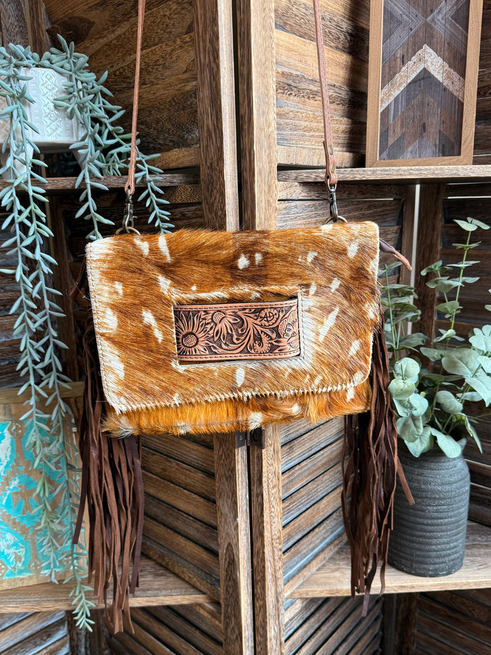 Fringed cowhide crossbody clutch with white spots and engraved front flap