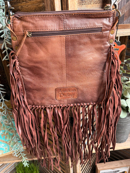 Leather fringed crossbody coin purse with embossed patch, zipper top, and dangling tassels