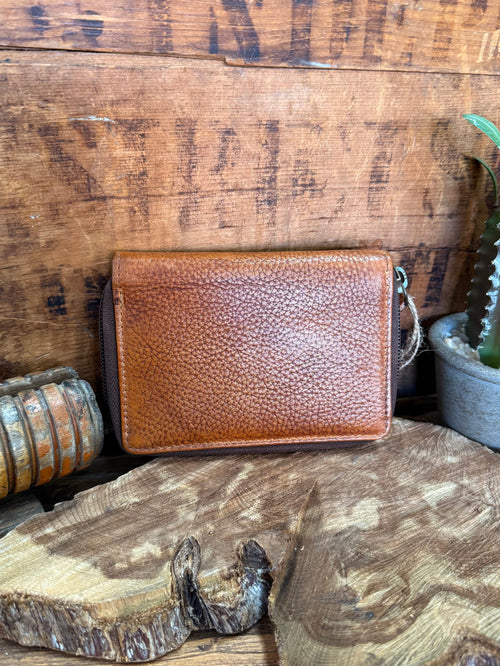 Brown cowhide zip coin wallet with textured grain and metal zipper