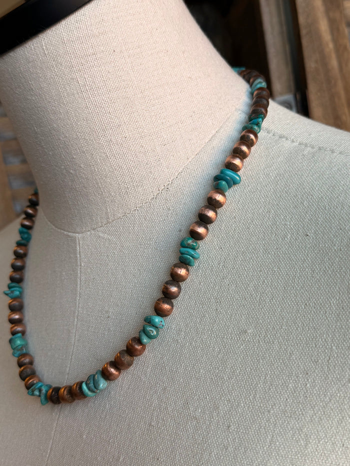 Turquoise and copper beaded necklace strand with round beads, side view