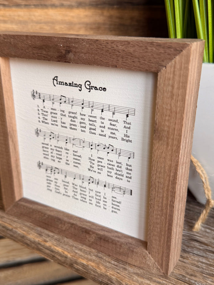 Wood-framed sheet music artwork with title and black printed notes