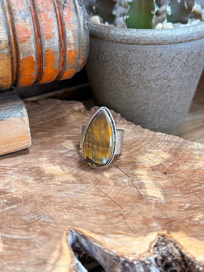 Adjustable stone ring with oval yellow tiger-eye cabochon in silver-toned bezel