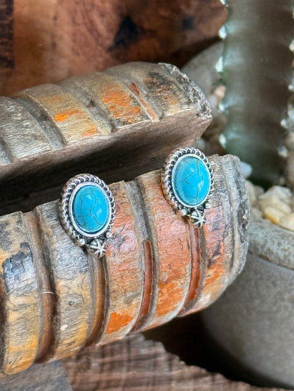 Silver oval turquoise stud earrings featuring oval turquoise stones and starburst dangle charms