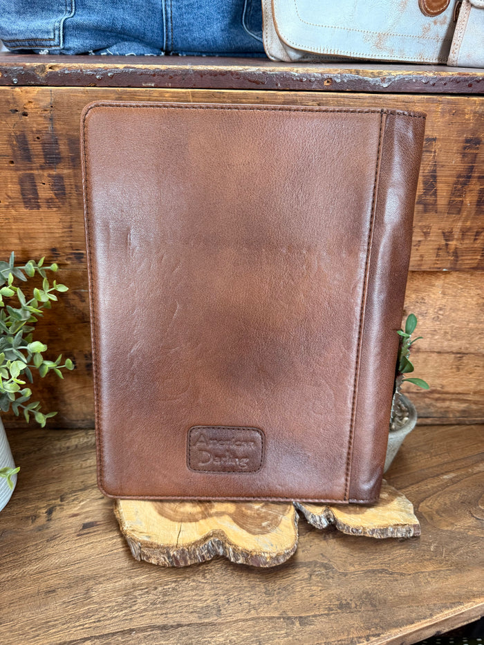 Brown leather folio notebook back panel with minimal embossed logo patch