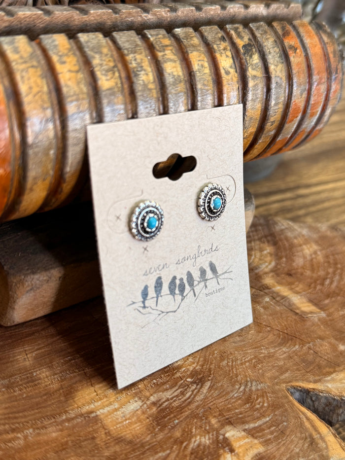 Silver concho stud earrings with turquoise cabochon centers, front view on card