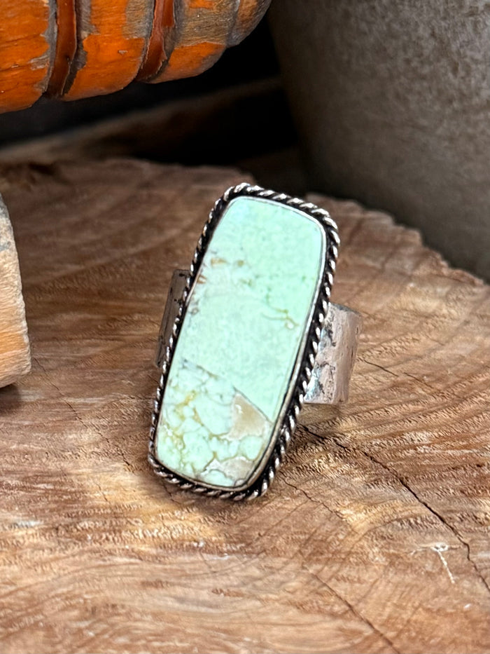 Silver-tone adjustable ring with oval turquoise-green stone and braided edge