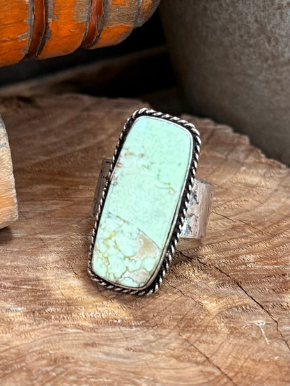 Silver-tone adjustable ring with oval turquoise-green stone and braided edge