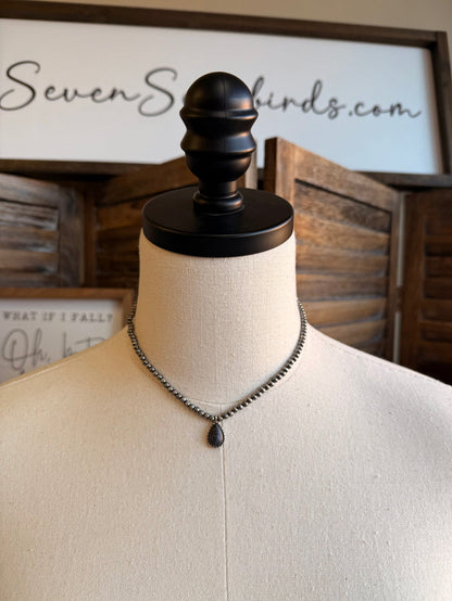 Silver-tone bead choker with dark drop charm and turquoise teardrop center pendant