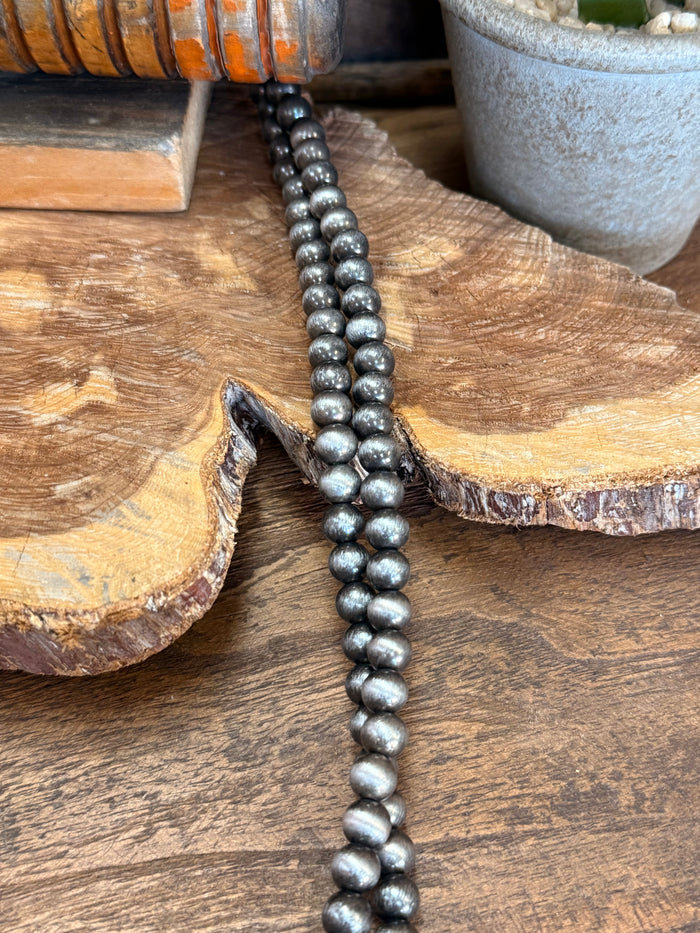 Close-up: endless necklace strand with dark gray round pearl beads
