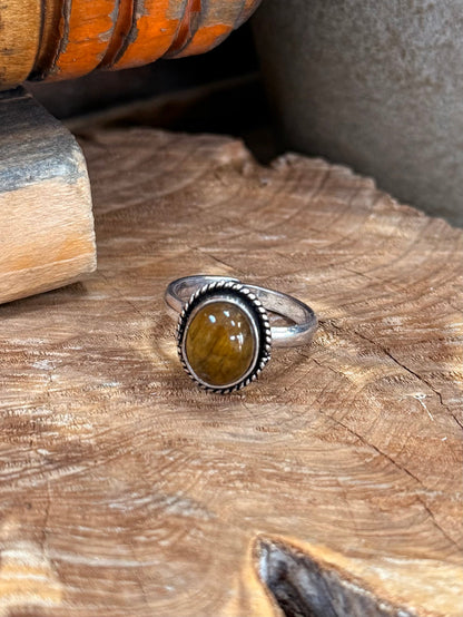Silver oval amber stone ring with textured bezel and slim open adjustable band