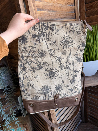 Flap canvas bag with blue floral print and brown leather bottom with front snap pocket